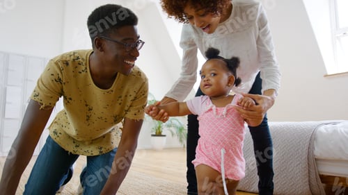 Preview: Baby Girl Learning To Walk At Home As Parents Help And Give Encouragement