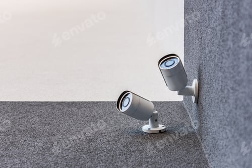 Preview: bottom view of two security cameras on office building, security system concept