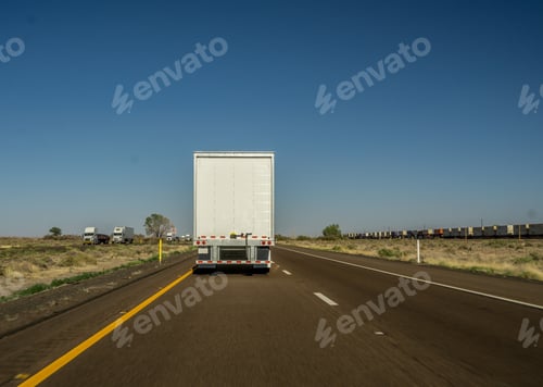 Preview: View from behind of a tractor trailer truck driving in the passing lane on an interstate highway