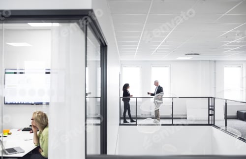 Preview: Colleagues having a conversation in a modern office space.