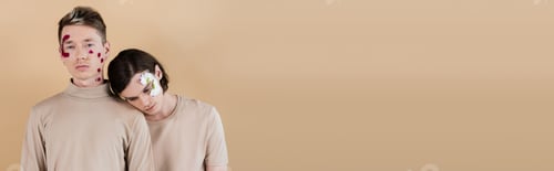 Preview: Same sex couple with petals on faces standing isolated on beige, banner