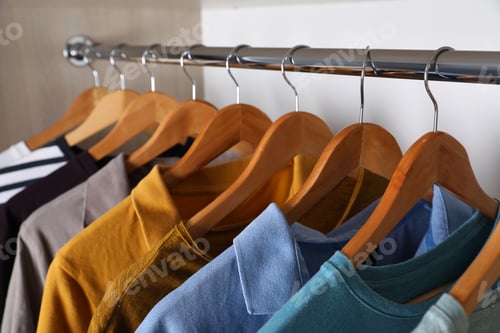 Preview: Colorful Shirts Hanging in Closet on Wooden Hangers