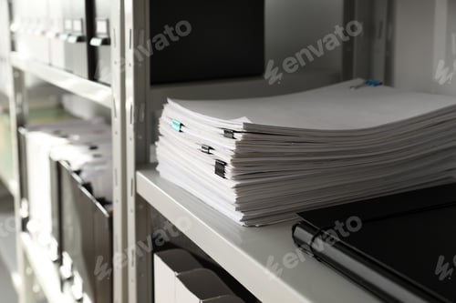 Preview: Stack of documents with paper clips on shelf in office