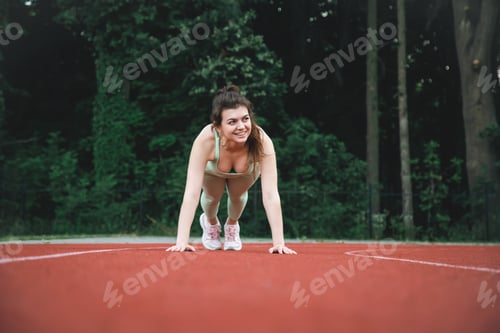 Preview: A young woman at the starting line in the stadium.
