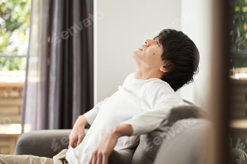 Preview: Asian man relaxing in the living room