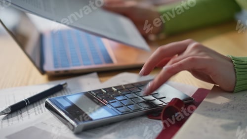 Preview: Accountant hand pressing calculator buttons working at wooden table closeup