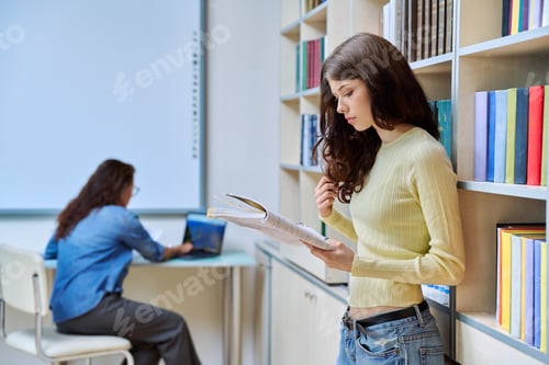 Preview: Portrait of teenage beautiful girl high school student reading textbook in library classroom