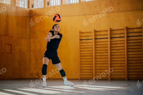 Preview: An interracial volleyball player in action passing a ball on court.