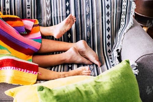 Preview: Couple having sex activity concept with nude feet and coloured cover on the sofa
