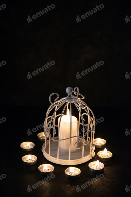 Preview: front view of burning candle in lamp as memory for fallen on dark surface israel war death