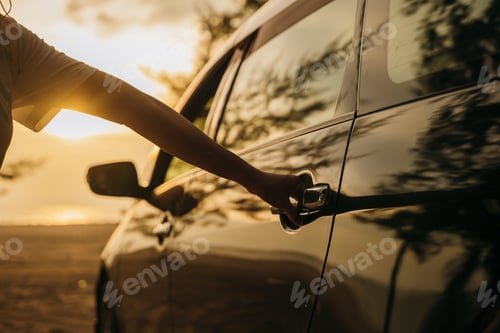 Preview: Close up young woman hand opening opening the door of a car at sunset. Hand holding door hand to