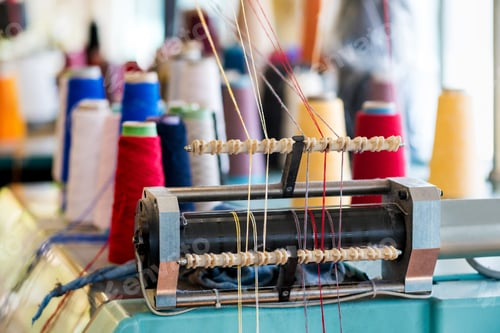 Preview: Yarn feeder with threaded wool on machine at a knitwear factory