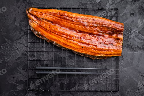 Preview: Japanese unagi eel, grilled fish fillet of eel. black background. top view