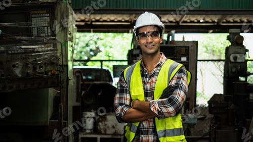 Preview: engineer in a factory, middle eastern smiling worker wearing white hat