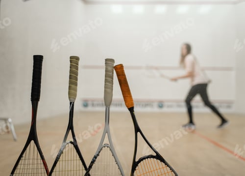 Preview: Squash rackets, female player on background