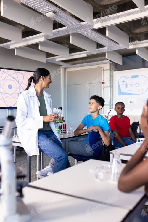 Preview: In school, Indian female teacher explaining science experiment to students in classroom laboratory