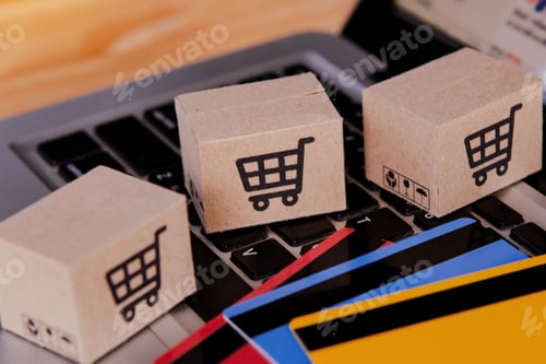 Preview: Shopping online. Credit card and cardboard box with a shopping cart logo on laptop keyboard.