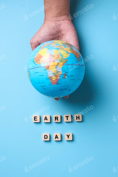 Preview: Top view of globe on palms with earth day lettering