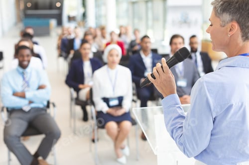 Preview: Female speaker speaks with microphone to business people in a business seminar in a conference room