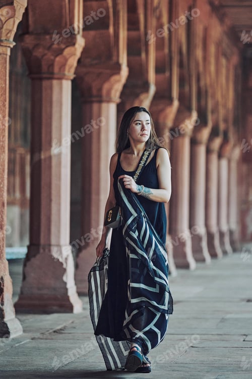 Preview: East asian woman in black dress dancing with translucent scarf among columns of ancient temple