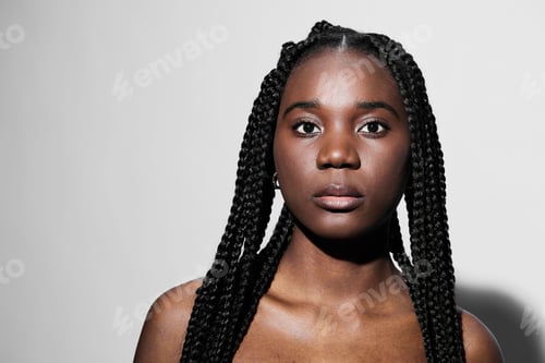 Preview: Confident young woman with braided hair, neutral expression, showcasing natural beauty against a