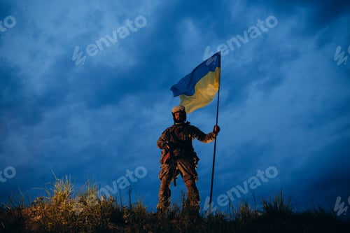 Preview: Armed Ukrainian warrior with blue and yellow flag in the evening