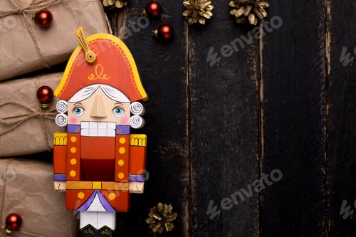 Preview: Nutcracker toy with gifts with a New Year's decor on a wooden background