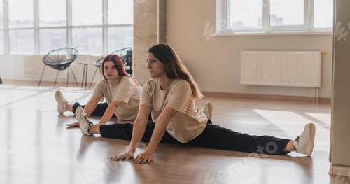 Preview: the two girls on a group fitness training class in the gym doing stretching workout