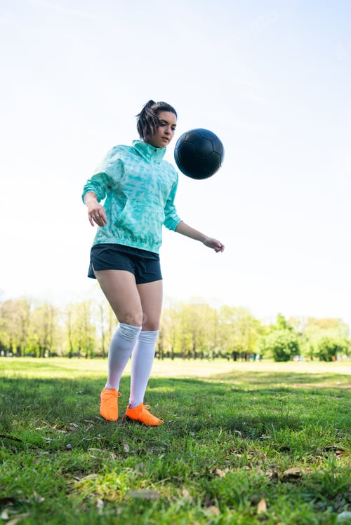 Preview: Young woman practicing soccer skills with ball.