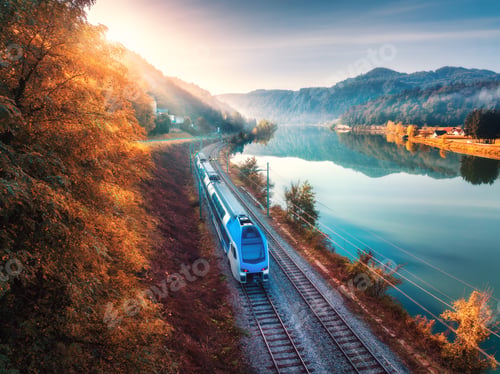 Preview: Aerial view of high speed train moving near lake in mountains