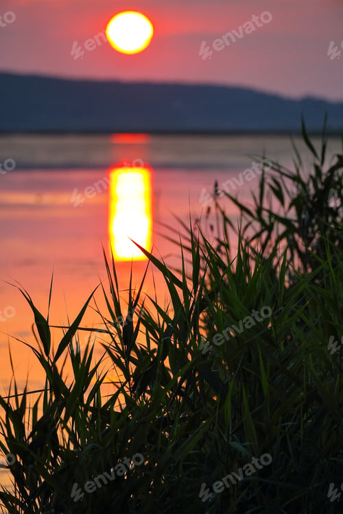 Preview: Amazing sunset over calm lake.
