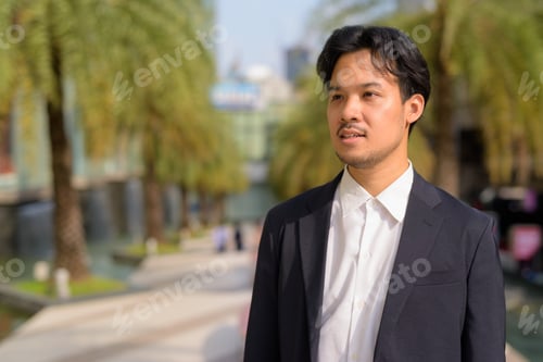 Preview: Portrait of Asian businessman outdoors in the city
