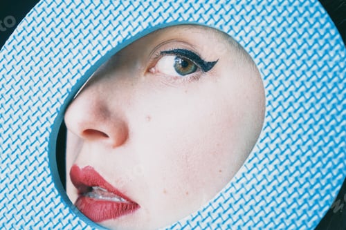 Preview: Pretty young woman face behind a blue circle