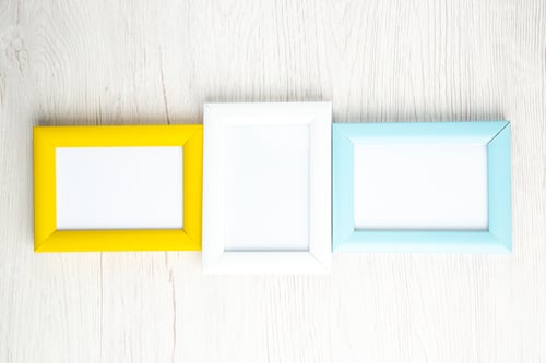 Preview: Top view of three picture frames laid side by side on white stripped background with free space