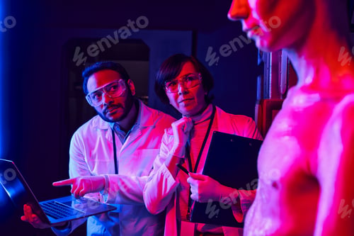 Preview: indian scientist pointing at laptop near thoughtful colleague and alien in discovery center