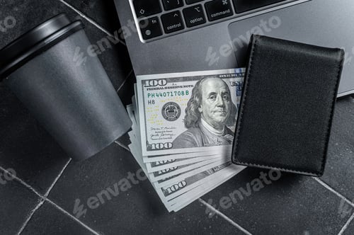 Preview: Corporate business desktop with laptop, digital tablet, wallet, money and cup of coffee.