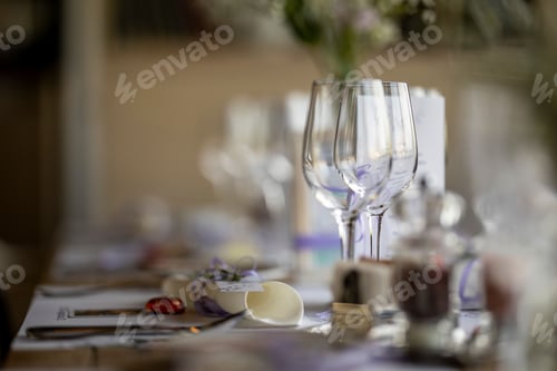 Preview: Closeup of a festive table with white dishes and glasses, blurred background