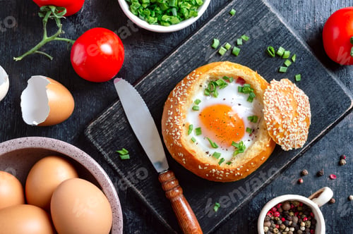 Preview: Delicious egg breakfast: egg baked in a bun. Top view, flat lay.