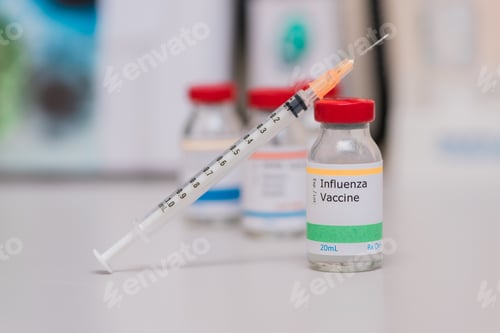 Preview: flu shot vaccination concept, syringe next to influenza vaccine vial