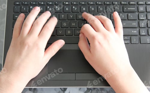 Preview: A child's hands typing away on a computer laptop keyboard