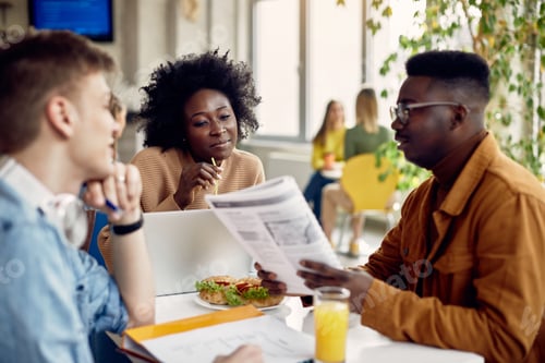Preview: Group of college students learning during lunch break in cafeteria.