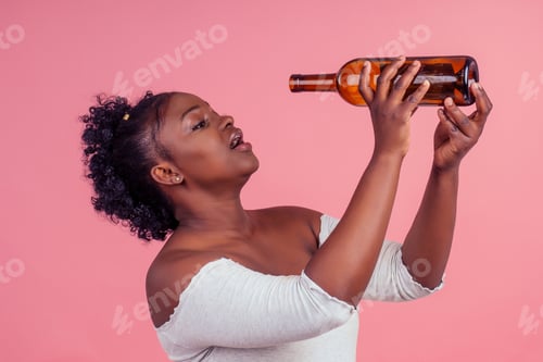 Preview: woman holding alcohol bottle in pink studio background