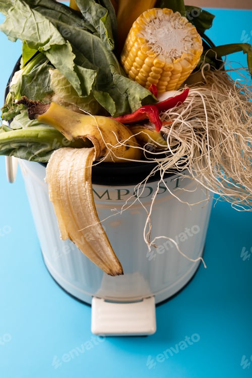 Preview: High angle view of organic waste in compost bin on blue background