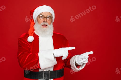 Preview: Santa Claus showing pointing fingers aside advertising Christmas New Year isolated red background