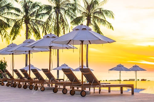 Preview: Umbrella and deck chair around outdoor swimming pool in hotel resort