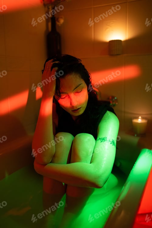 Preview: Depressed asian woman sit in bath with cold water think of love problem, break up or ruined marriage