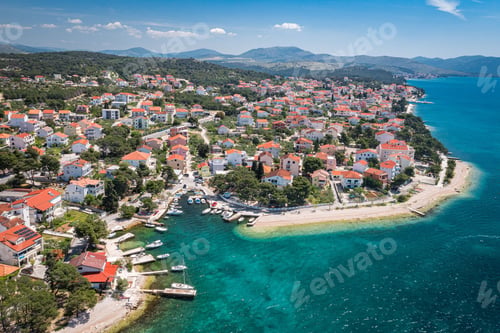 Preview: Aerial view of an idyllic coastal scene featuring a tranquil blue ocean and bright white buildings