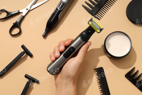Preview: Men's shaving tools, hand and jar of cream on beige background, top view