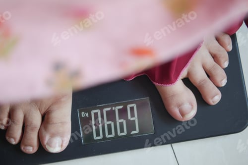 Preview: woman's feet on weight scale close up.
