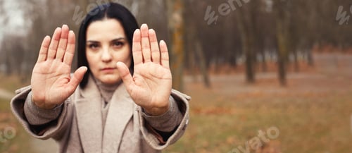 Preview: woman stretches her hands with open palms as a stop sign.